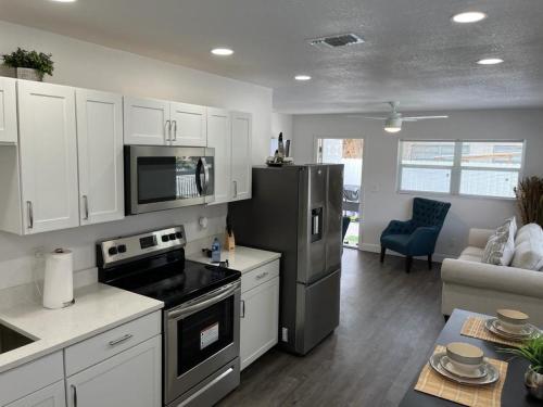 坦帕Incredible comfortable apartments near the airport and beaches的厨房配有白色橱柜和黑色冰箱。
