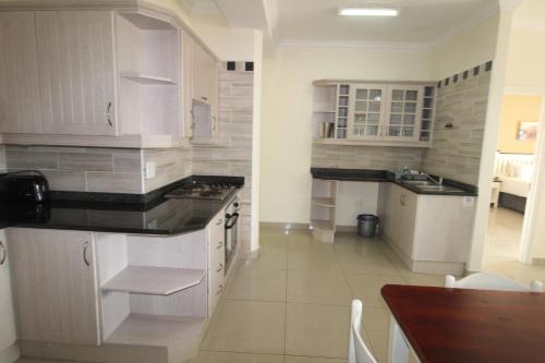 乌旺戈海滩Saints View Resort Unit 7的厨房配有白色橱柜和台面