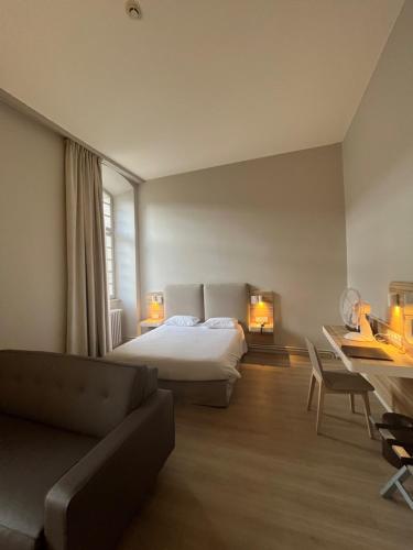 蓬塔穆松阿巴耶酒店的一间卧室配有一张床、一张沙发和一张书桌