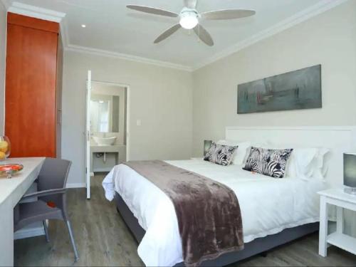 HoneydewEagle Cove的白色卧室配有床和吊扇