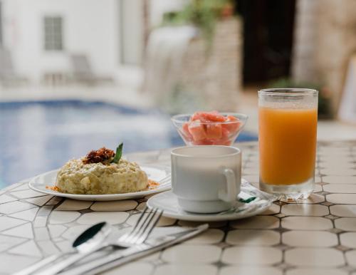 瓜亚基尔Hotel Patrimonial by Greenfield的一张桌子,上面放着一盘食物和一杯橙汁