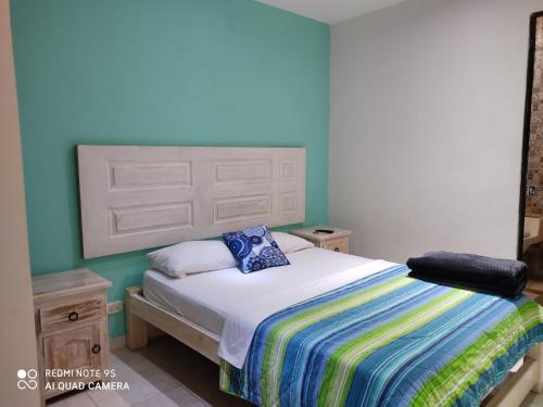 萨兰托Hostal Los balcones的一间卧室设有一张床和蓝色的墙壁