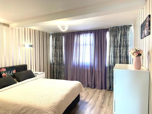 艾森纳赫Ferienwohnung Appartamento Da Vinci的一间卧室配有一张床和一个带紫色窗帘的窗户