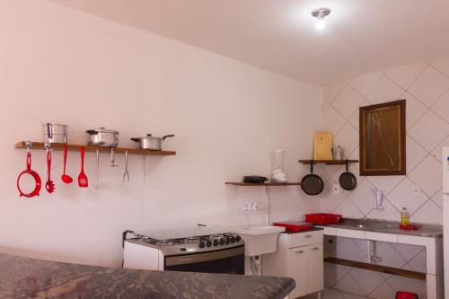 凯鲁Casa do Pepe的厨房配有炉灶和带餐具的台面。