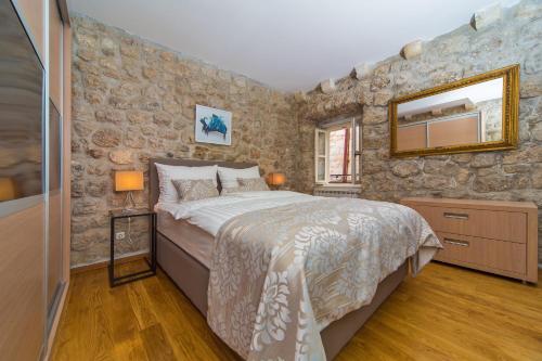 杜布罗夫尼克Dubrovnik Dream Apartments的一间卧室设有一张床和石墙