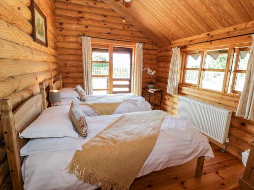 斯塔福德Far Coley Farm and Kilnhurst Log Cabin的小木屋内一间卧室,配有两张床