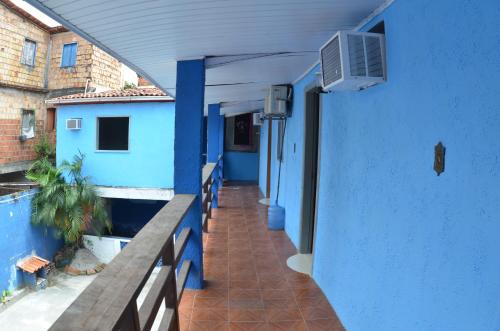 伊塔卡雷Suítes good trip itacare的带阳台的蓝色建筑走廊