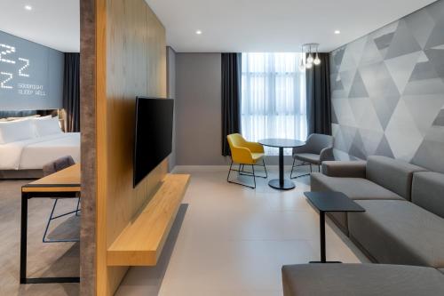 迪拜Studio M Al Barsha Hotel by Millennium的酒店客房设有沙发和桌子