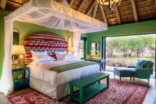 荆棘丛自然保护区罗伊尔马尔瓦纳山林小屋的一间卧室设有一张大床和一个大窗户