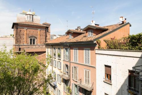 米兰Heart Milan Apartments Porta Romana的两只猫坐在建筑物的屋顶上