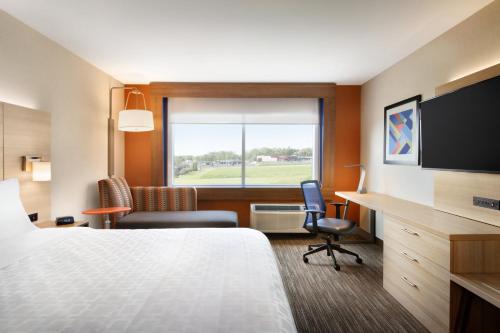 米德尔敦Holiday Inn Express & Suites - Middletown, an IHG Hotel的配有一张床、一张书桌和一扇窗户的酒店客房