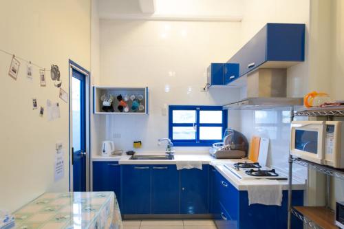 Gongzhao太平山愛琴海的厨房配有蓝色橱柜和白色炉灶烤箱。