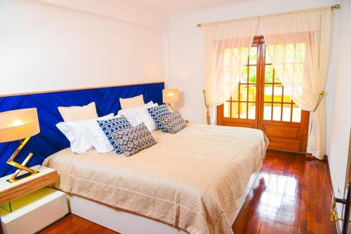 辛特拉Charming Home in Sintra Village的一间卧室配有一张大床和蓝色床头板