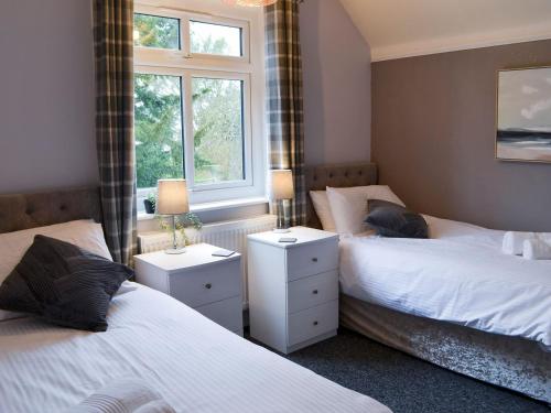 斯凯格内斯Nalas Cottage的一间卧室设有两张床和窗户。