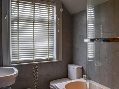 斯凯格内斯Nalas Cottage的一间带卫生间、水槽和窗户的浴室