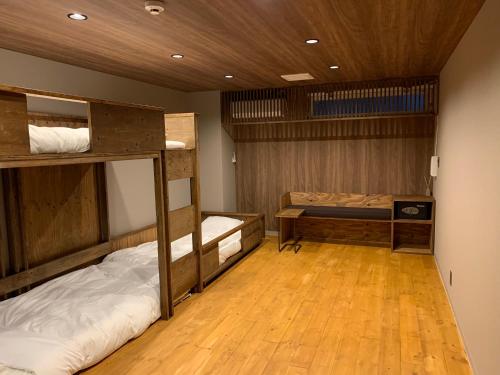 广岛Hotel San Hiroshima的客房设有两张双层床,铺有木地板。