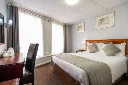 伯明翰伯明翰舒适之家酒店的酒店客房设有一张床、一张书桌和窗户。