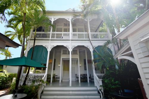 基韦斯特西蒙顿庭院历史小屋宾馆的一座棕榈树掩映的白色房子