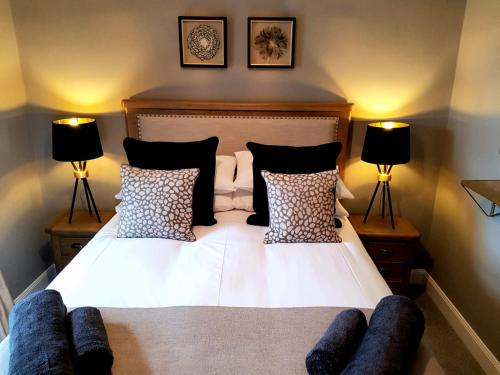 因弗内斯Glencoe House Inverness的一张带黑白枕头的床和两盏灯