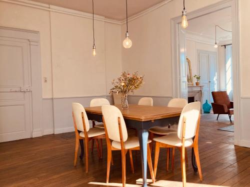 奥比松l'Albuconis7 Appartement 160m2的一间带木桌和椅子的用餐室