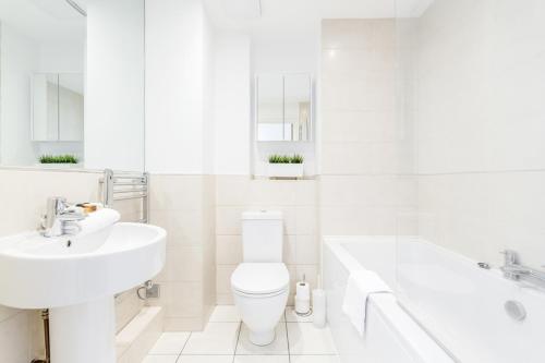 吉尔福德Roomspace Serviced Apartments - Abbot's Yard的白色的浴室设有水槽、卫生间和浴缸。
