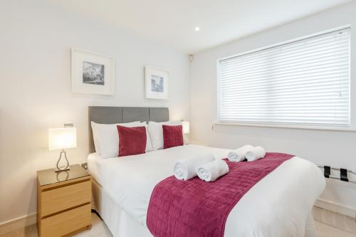 吉尔福德Roomspace Serviced Apartments - Abbot's Yard的卧室配有带毛巾的大型白色床