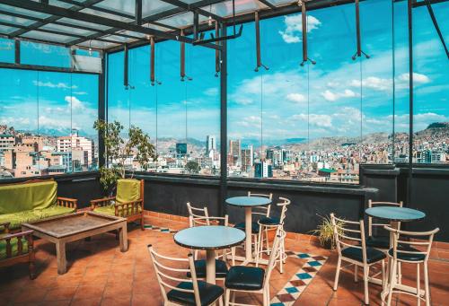 拉巴斯The Rooftop Bolivia的设有带桌椅的市景阳台。