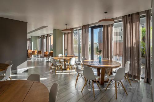 贝洛奥里藏特贝洛奥里藏特萨瓦斯丽笙酒店的用餐室设有桌椅和窗户。