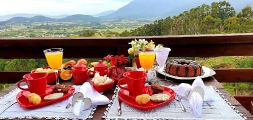圣阿马鲁-达因佩拉特里斯Chalé da Montanha com Ofurô的一张桌子,上面放着一盘食物和橙汁