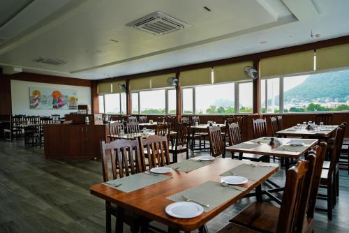 维杰亚瓦达Eden Park Boutique Hotel的用餐室设有桌椅和窗户。