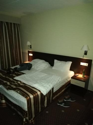 瓦尔考斯Hostel Varkaus的一张大床,位于酒店房间,地板上穿鞋