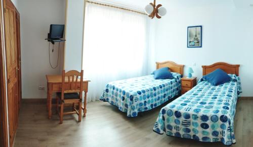 圣维森特-德拉巴尔克拉圣地亚哥阿尔托公寓的一间卧室设有两张床、一张桌子和一个窗口。