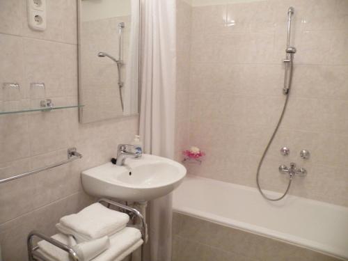 布达佩斯布达佩斯布达公寓式酒店的浴室配有盥洗盆、淋浴和盥洗盆。