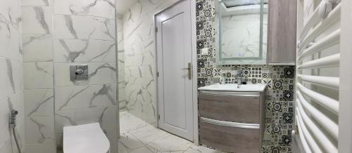 布米尔达斯Le Rocher的一间带卫生间、水槽和镜子的浴室