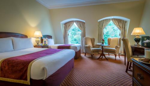 肯尼迪山新镇格兰维尔酒店及休闲俱乐部的酒店客房带两张床和一张桌子以及椅子。