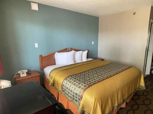 孟菲斯速7汽车旅馆的酒店客房配有一张床铺和一张桌子。