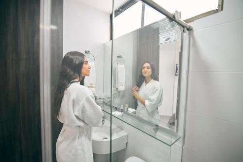 库库塔Bianco Hotel Boutique的女人在浴室镜子里看着她的反射