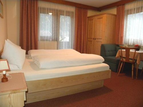 迈尔霍芬安贝尔格旅馆的一间卧室配有一张床、一把椅子和窗户。