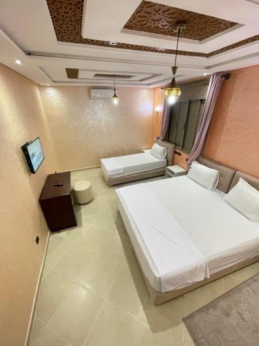 拉希迪耶IGHIZ INN resort的一间带两张床的卧室和一台电视