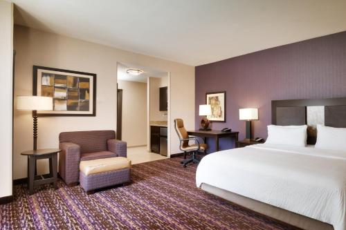 比林斯比林斯智选假日酒店及套房的酒店客房配有一张床、一张桌子和一把椅子。