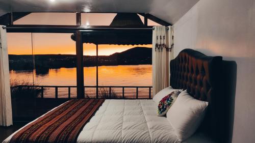 普诺Uros Utasa Lodge的一间卧室配有一张床,享有水景