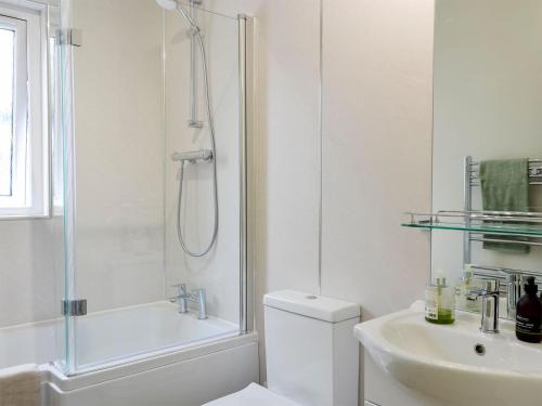 EdzellThe Butchers Cottage的带淋浴、卫生间和盥洗盆的白色浴室