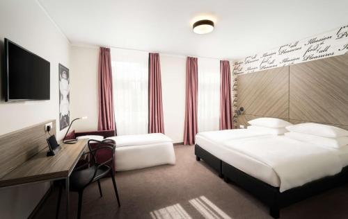 维也纳elaya hotel vienna city west的酒店客房配有两张床和一张书桌
