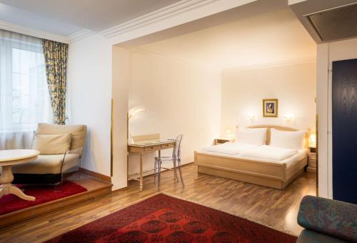 维也纳ANA加拉艺术酒店的一间卧室配有一张床、一把椅子和一张桌子