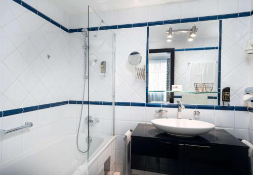 维也纳ANA加拉艺术酒店的白色的浴室设有水槽和淋浴。
