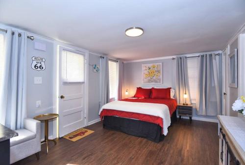 塔尔萨BLUE FLAMINGO'S ADORABLE GUEST HOUSE -TU-Cherry St-Expo-Downtown-11t的一间卧室配有一张带红色枕头的床和一把椅子