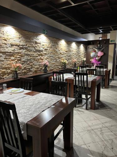 克鲁舍瓦茨Garni Hotel City的一间带桌椅和石墙的餐厅