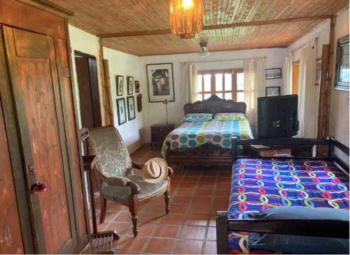 马尼萨莱斯Mirador de los Vientos的一间卧室配有一张床、一把椅子和电视。