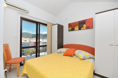 尼亚卢卡Apartments by the sea Vela Luka, Korcula - 9243的一间卧室设有一张黄色的床和一个阳台