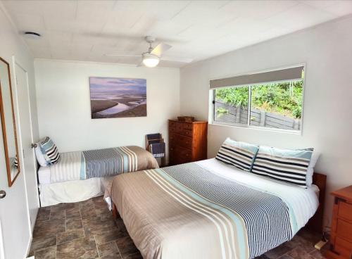 OpuaWater's Edge Holiday Home的一间卧室设有两张床和窗户。